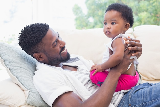 Glücklicher Vater mit Baby auf Couch