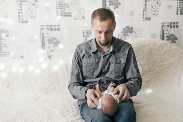 Glücklicher Vater mit einem neugeborenen Baby in seinen Armen