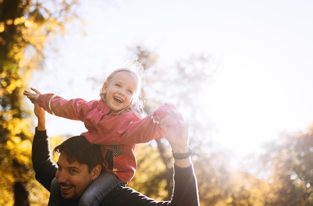 Glücklicher Vater mit kleiner Tochter im Herbst Park Erholung im Freien Vater und Tochter