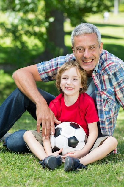 Glücklicher Vater mit seinem Sohn am Park an einem sonnigen Tag