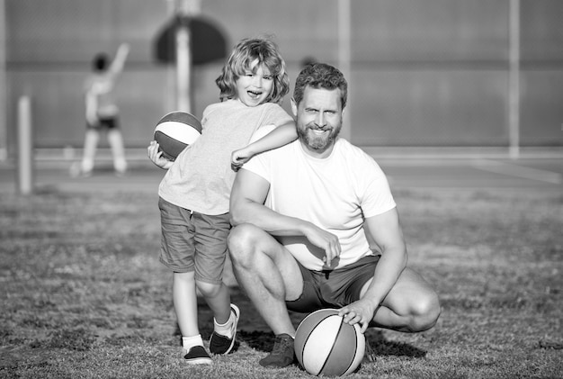 Glücklicher Vater und Kind spielen Basketball mit Kindheit im Freien