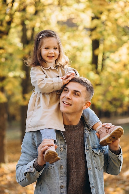 Glücklicher vater und kleine tochter, die im vatertagskonzept des herbstparks spazieren gehen