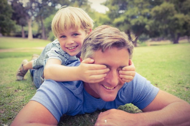 Glücklicher Vater und sein Sohn, die an der Kamera lächelt