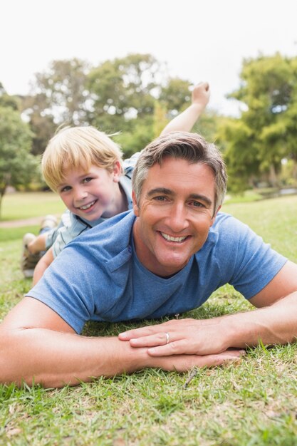 Foto glücklicher vater und sein sohn, die an der kamera lächelt