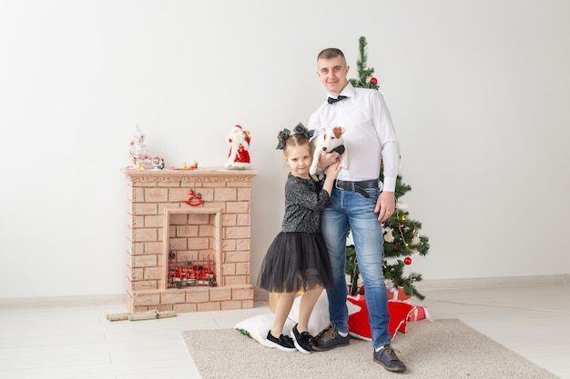 Glücklicher Vater und seine Tochter zu Hause mit Weihnachtsbaum