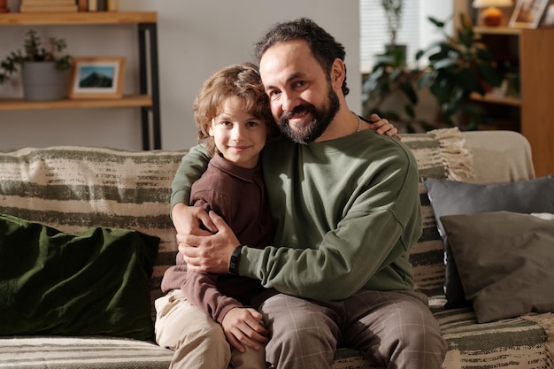 Glücklicher Vater und Sohn sitzen auf der Couch