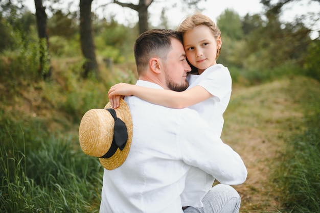 Glücklicher Vater und Tochter spielen beim Gehen in einem schönen Sommerpark Idealer Wochenendvater mit seiner kleinen Tochter