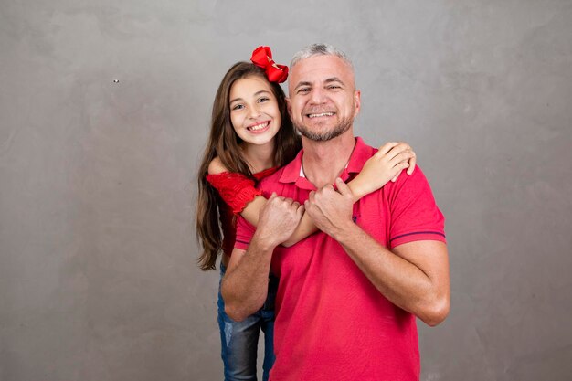 Glücklicher Vatertag Glücklicher kaukasischer Vater und Tochter, die sich auf einfachem Hintergrund mit Kopierraum umarmen