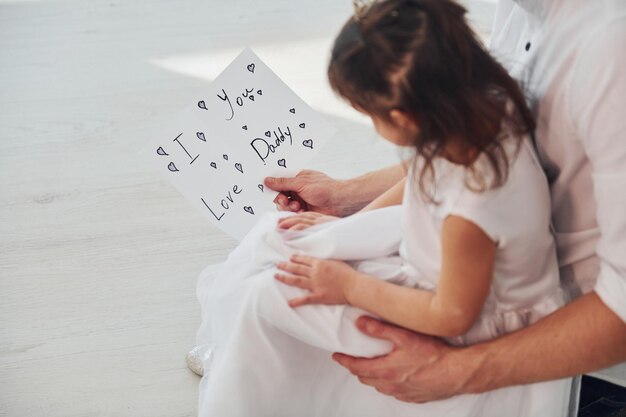 Glücklicher Vatertag Tochter überrascht Papa, indem sie Postkarte mit Herz gibt