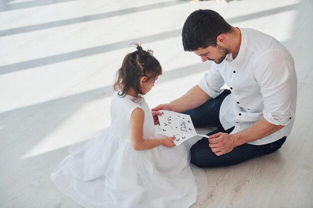 Glücklicher Vatertag Tochter überrascht Papa, indem sie Postkarte mit Herz gibt