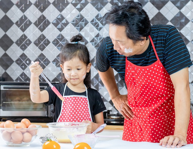 glücklicher Vati und kleine Tochter, die in der Küche kochen