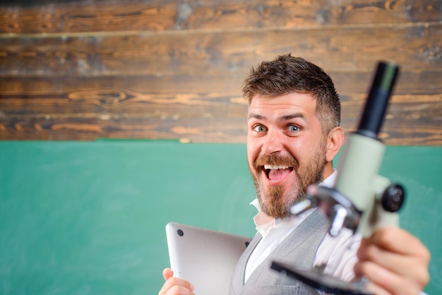 Glücklicher Wissenschaftler mit Laptop und Mikroskoplehrer mit Notebook und Mikroskop Biologie oder Chemie