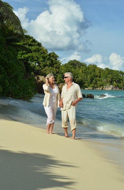 Glückliches älteres Ehepaar, das sich am Strand ausruht Reisen