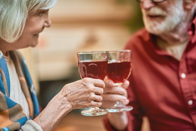 Glückliches älteres Ehepaar feiert beim Toasten mit Wein