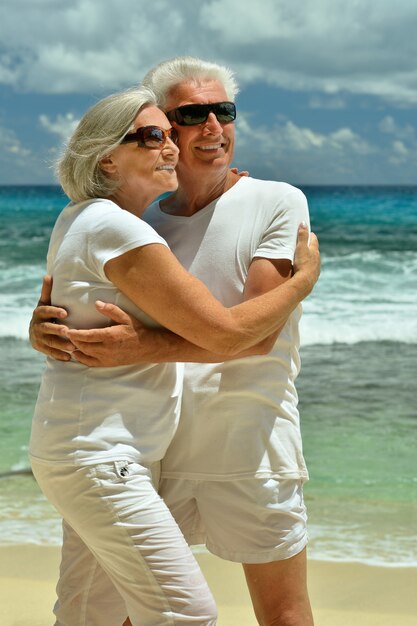 Glückliches älteres Ehepaar ruht sich am tropischen Strand aus