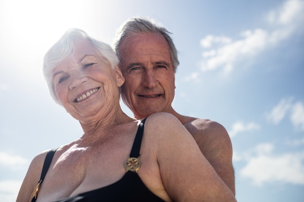 Glückliches älteres Paar, das am Strand umarmt