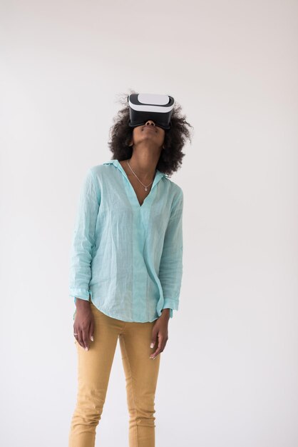 Glückliches afrikanisch-amerikanisches Mädchen, das Erfahrung mit VR-Headset-Brillen der virtuellen Realität sammelt, isoliert auf weißem Hintergrund