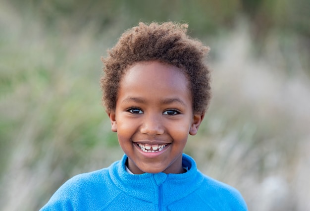 Glückliches afrikanisches Kind mit blauem Trikot