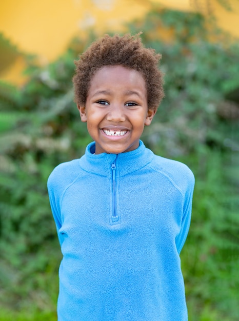 Glückliches afrikanisches Kind mit blauem Trikot