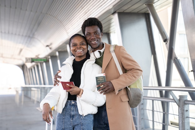 Glückliches afrikanisches Paar lächelt und hält seine Pässe am Flughafen?