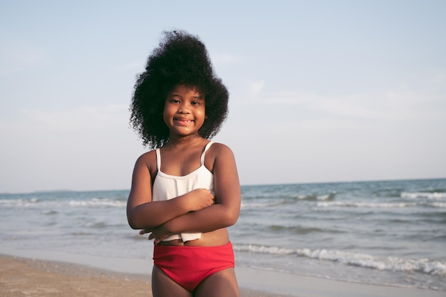 Glückliches Afro-Haarkindermädchen am Strand