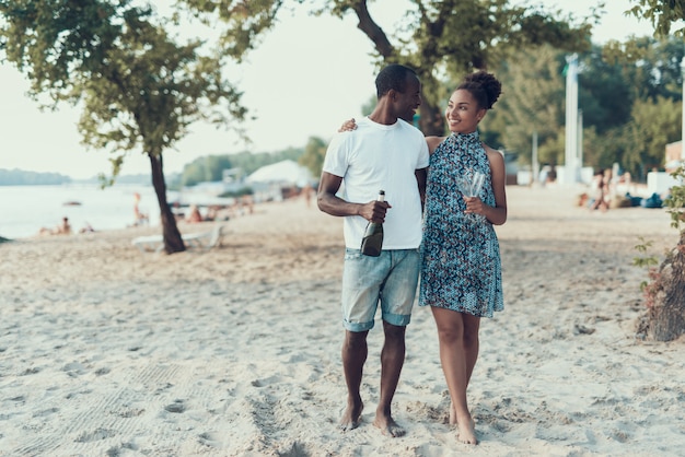 Glückliches afroamerikanisches Paar steht auf Sandy River Beach still.