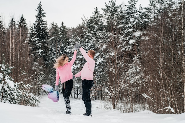 Glückliches aktives Paar im Winterwald, Moroz Tag, Lebensstil.
