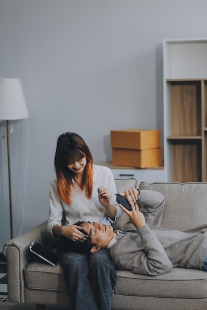 glückliches asiatisches junges attraktives paar mann und frau sitzen auf der couch benutzen tablet-shopping online möbel dekorieren zu hause im wohnzimmer in neuem haus jung verheiratet umziehen zu hause shopper online-konzept