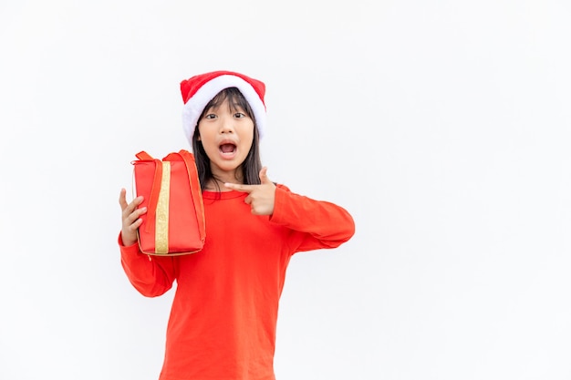 Glückliches asiatisches Kind in Santa Red Hat mit Weihnachtsgeschenken. Weihnachtszeit auf weißem Hintergrund.