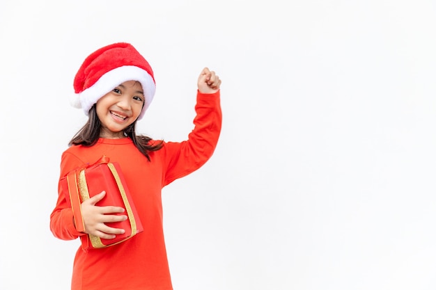 Glückliches asiatisches Kind in Santa Red Hat mit Weihnachtsgeschenken. Weihnachtszeit auf weißem Hintergrund.