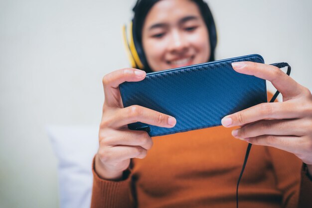 Glückliches asiatisches Mädchen mit hehadphones, das Musik hört.