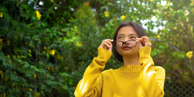 Glückliches asiatisches Mädchen tragen Brille in der Natur.