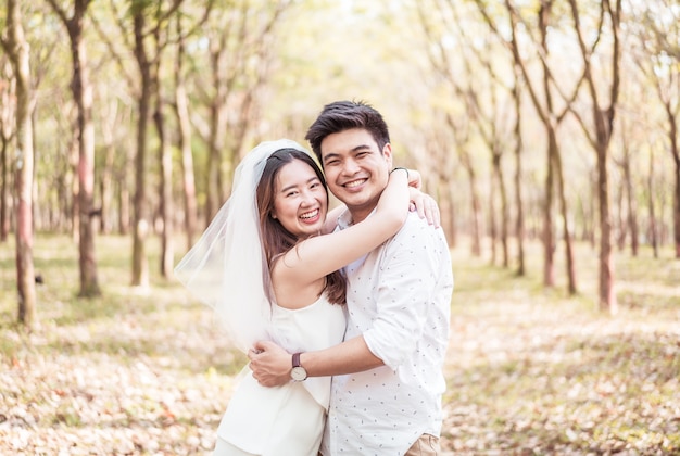 Glückliches asiatisches Paar verliebt in Baumbogen