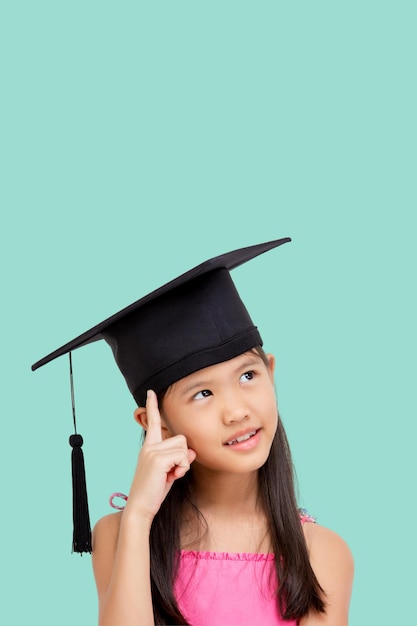 Glückliches asiatisches Schulmädchen mit Kopierbereich Studentisches Kind mit Abschluss in Abschlusskappe