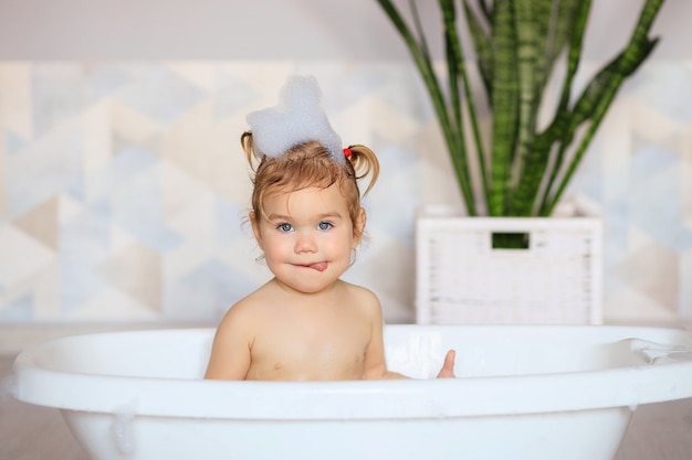 Glückliches Baby badet im Badezimmer