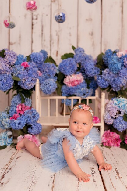 Glückliches Baby in einem Kleid im Studio auf einem weißen