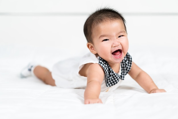 Glückliches Baby Neugeborenes auf einem Bett