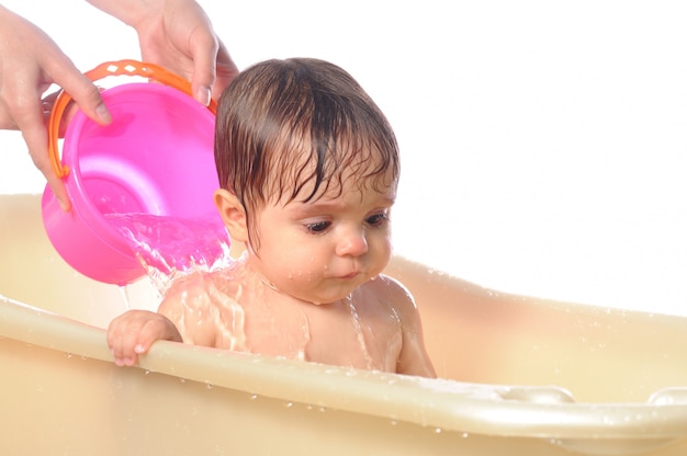 Glückliches Baby unter Wasserspritzern im Bad