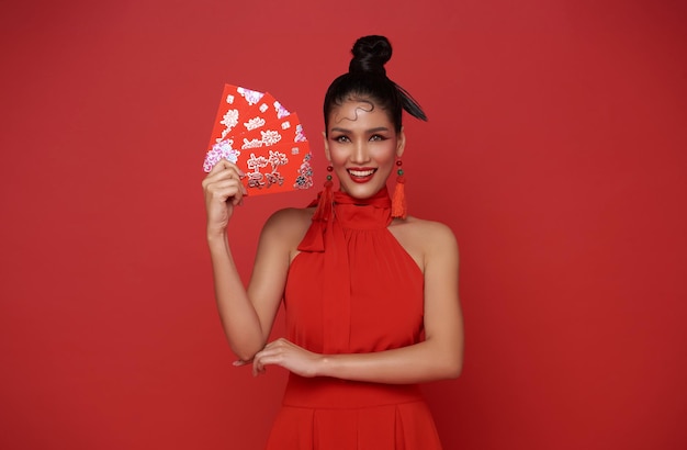 Glückliches chinesisches Neujahr. Asiatische Frau in rotem Kleid hält Angpao oder rotes Paket mit Geldgeschenken