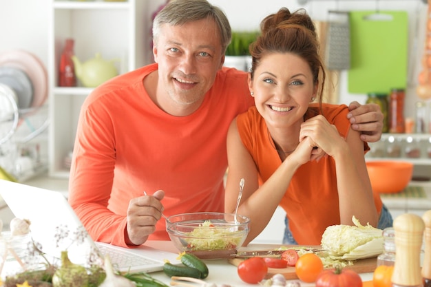 Glückliches Ehepaar, das zusammen in der Küche kocht