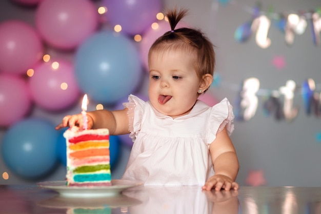 Glückliches einjähriges Kind mit einer Geburtstagstorte Kindergeburtstag