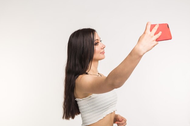 Glückliches europäisches weibliches Modell mit dunklem Haar, das Innen-Fotoshooting genießt