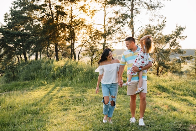 Glückliches Familienkonzept - Vater, Mutter und Kind Tochter, die Spaß haben und in der Natur spielen.