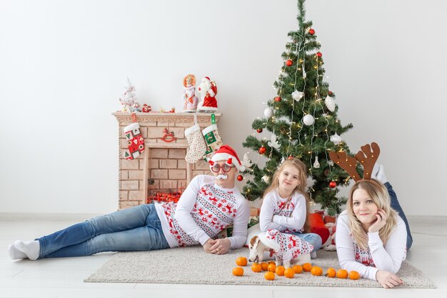 Glückliches Familienporträt durch Weihnachtsbaum