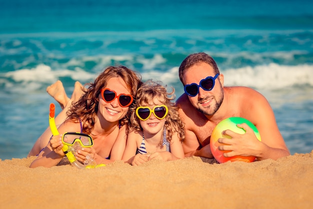 Glückliches Familienspiel am Strand Sommerferienkonzept