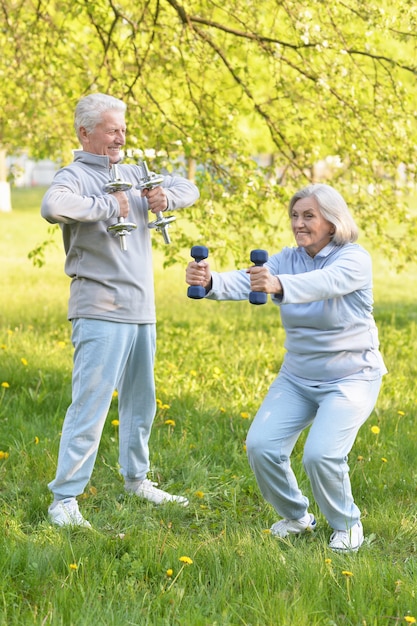 Foto glückliches fittes älteres paar, das im park trainiert