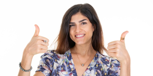 Glückliches Frauenlächeln, das zwei Daumen hoch gibt, übergibt die Finger über weißem Hintergrund