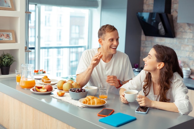 Glückliches gerade verheiratetes Paar, das zusammen frühstückt