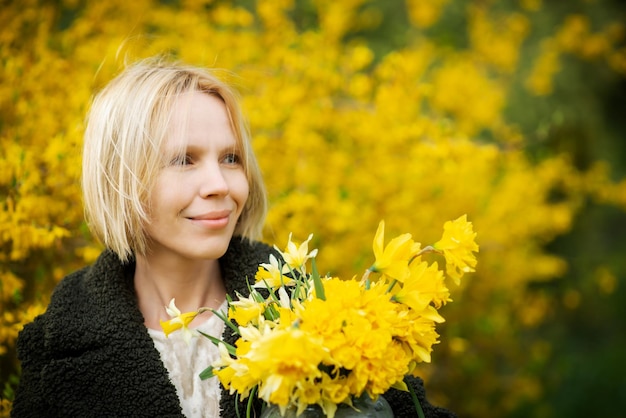 Glückliches Gesicht Licht Gedanken Träume Frau auf einem gelben Hintergrund mit gelben Blumen Lächelnde blonde Frau mittleren Alters vierzig plus Platz für Text