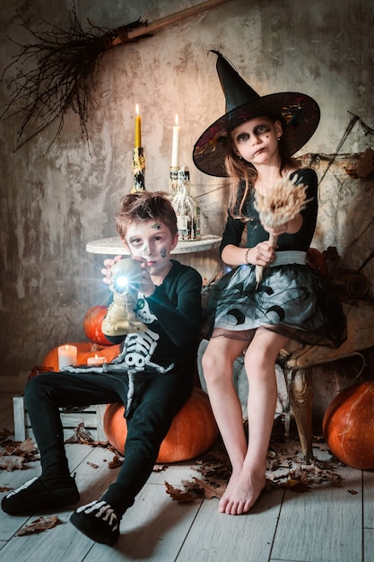 Glückliches Hexenmädchen und Jungen an Halloween.